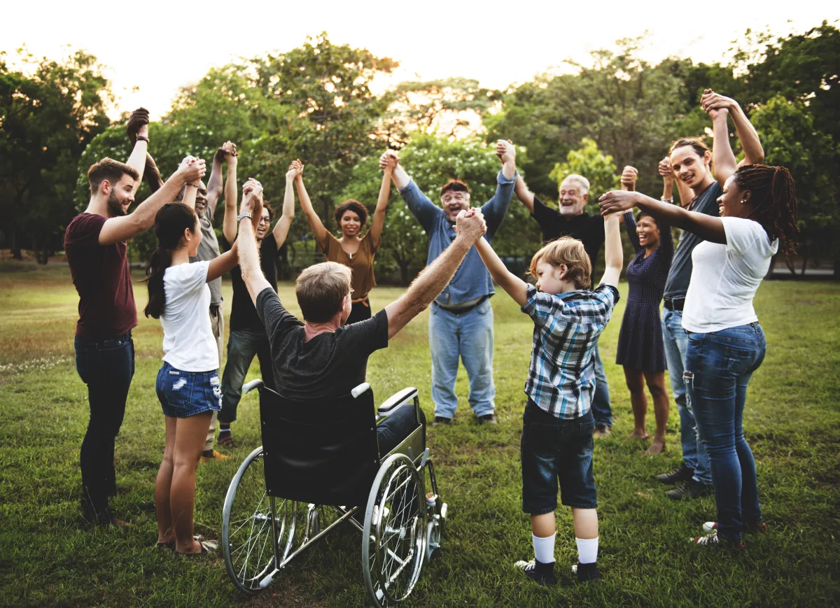 A group joining hands outdoors